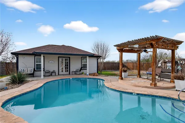 a view of a house with swimming pool and sitting area