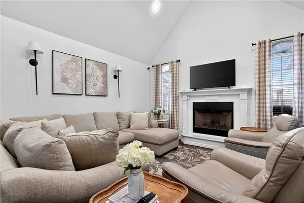 a living room with furniture a flat screen tv and a fireplace