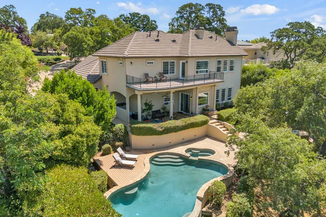 a front view of a house with a garden and swimming pool