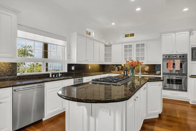 a kitchen with stainless steel appliances granite countertop a sink and dishwasher stove with wooden floor