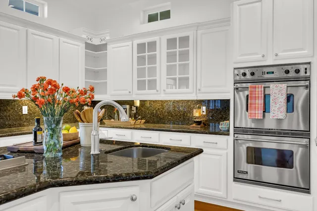 a kitchen with stainless steel appliances granite countertop a sink stove and cabinets