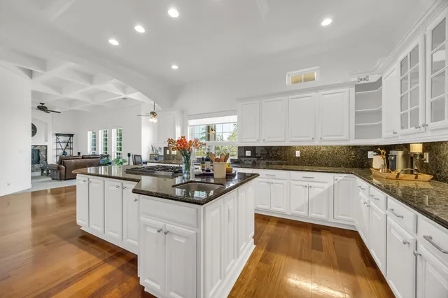 a kitchen with stainless steel appliances granite countertop a stove and white cabinets