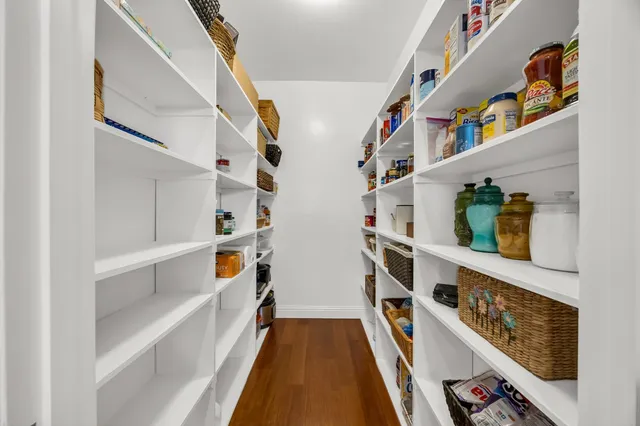 a view of walk in closet with clothes and shoes