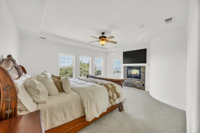 a spacious bedroom with a bed and a flat screen tv