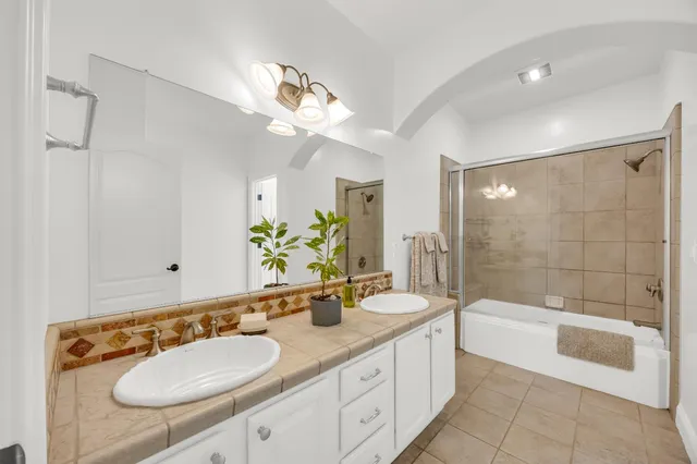 a bathroom with a sink a tub and a mirror