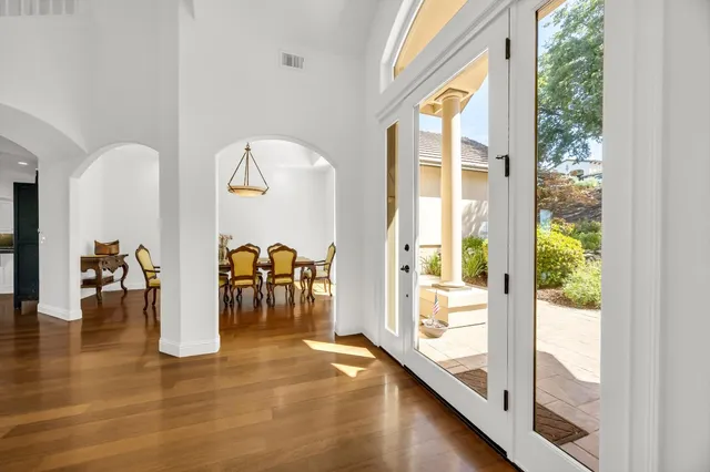 a view of a living room with a floor to ceiling window and wooden floor