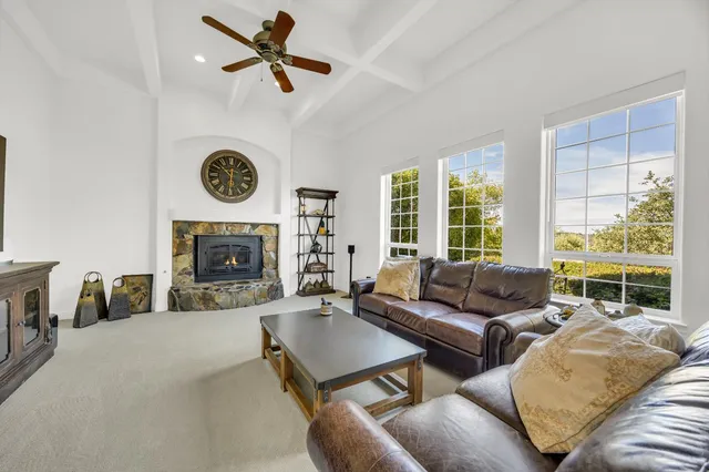 a living room with furniture a large window and a fireplace