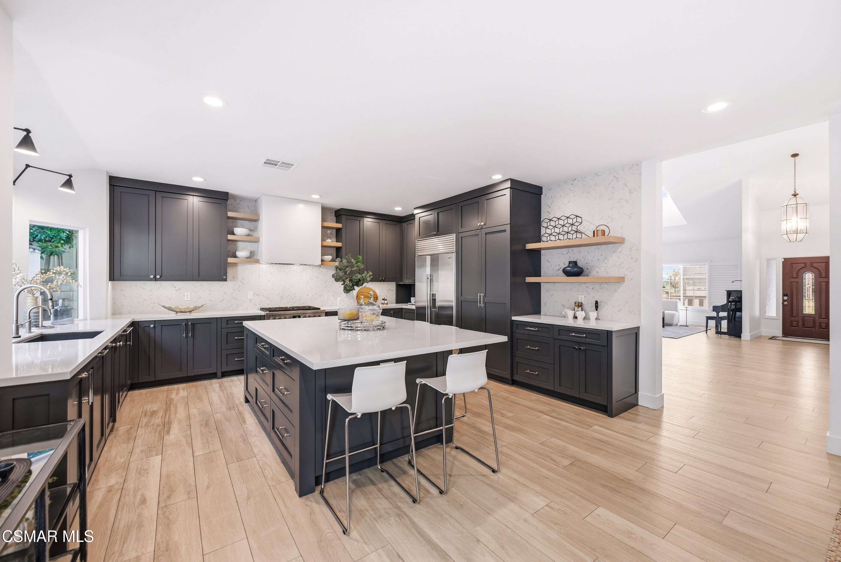 2810 Rikkard Drive Thousand Oaks, CA 91362 - Photo 10 of 38 a kitchen with stainless steel appliances kitchen island granite countertop a stove a refrigerator a sink a dining table and chairs with wooden floor