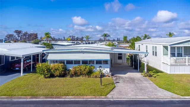 a view of a white house with a yard and potted plants