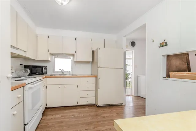 a kitchen with white cabinets and white appliances