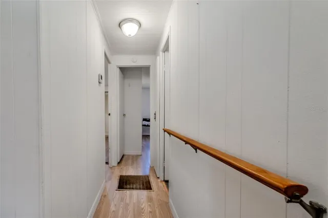 a view of a hallway with wooden floor and staircase