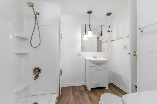 a bathroom with a sink a toilet and shower