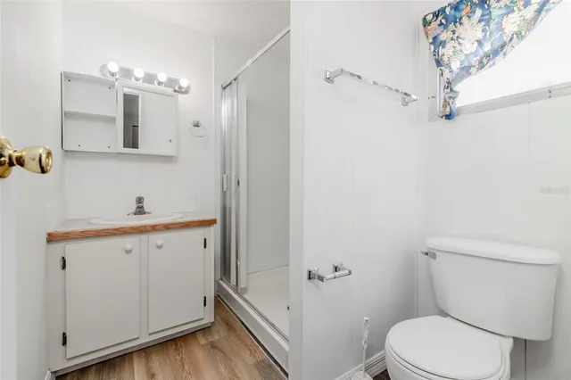 a bathroom with a granite countertop sink a toilet a shower and a mirror