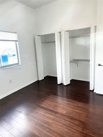 an empty room with wooden floor and closet