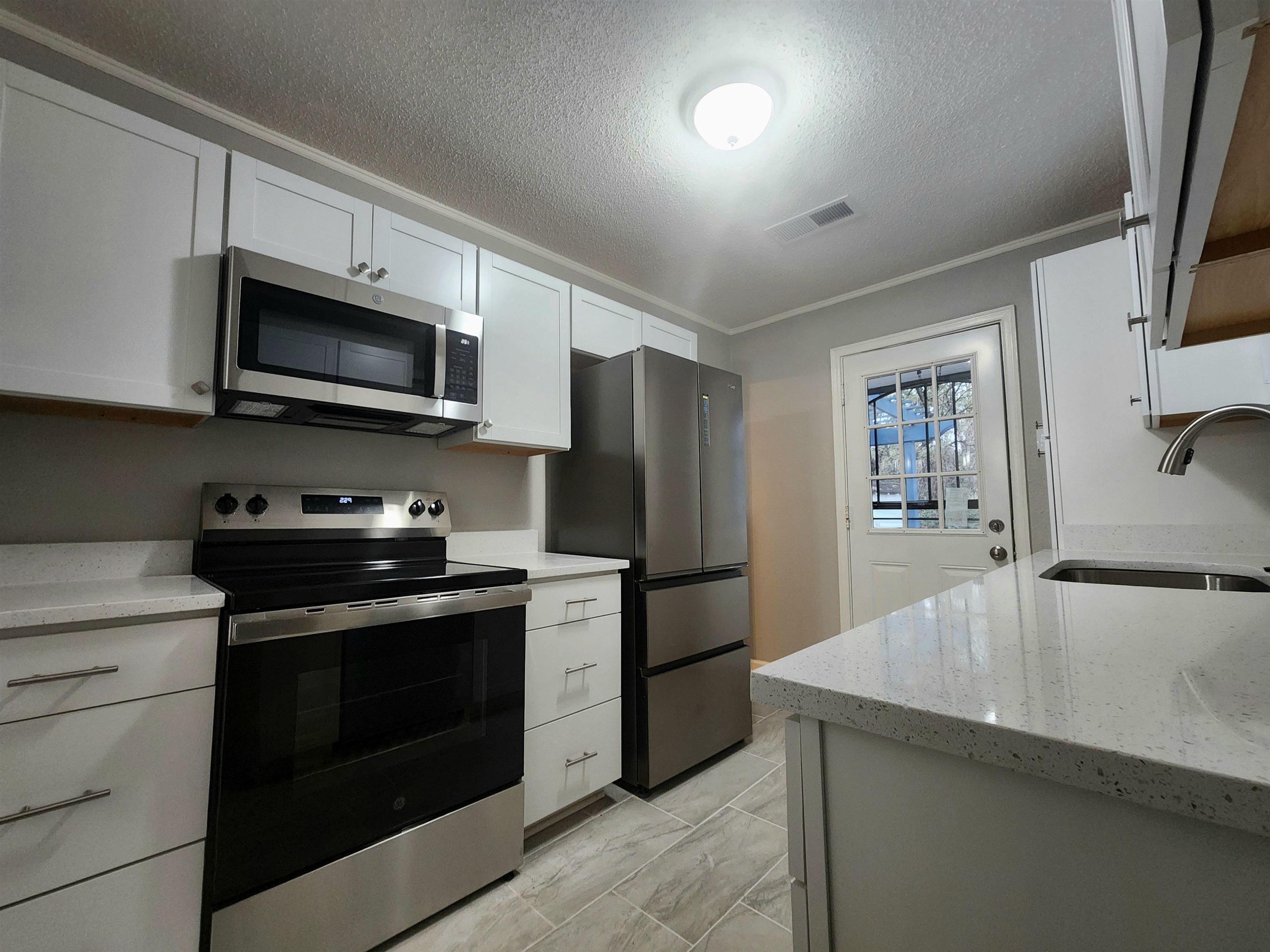 866 Colonial Road Memphis, TN 38117 - Photo 9 of 15 a kitchen with granite countertop a refrigerator stove and microwave