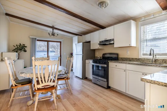 a kitchen with granite countertop wooden floors and white appliances