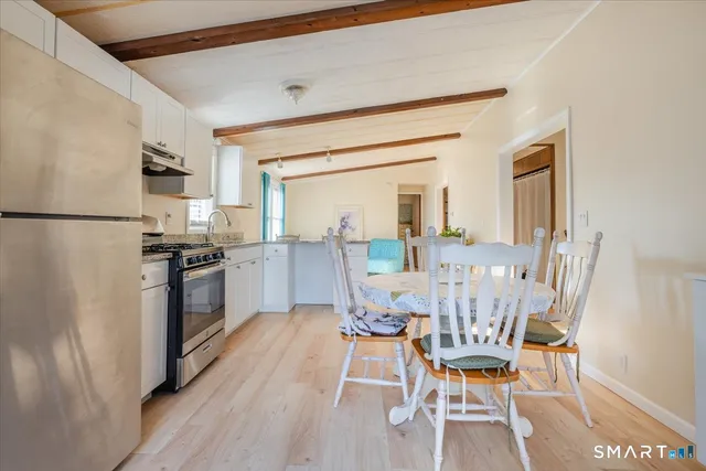 a dining room with furniture and kitchen view