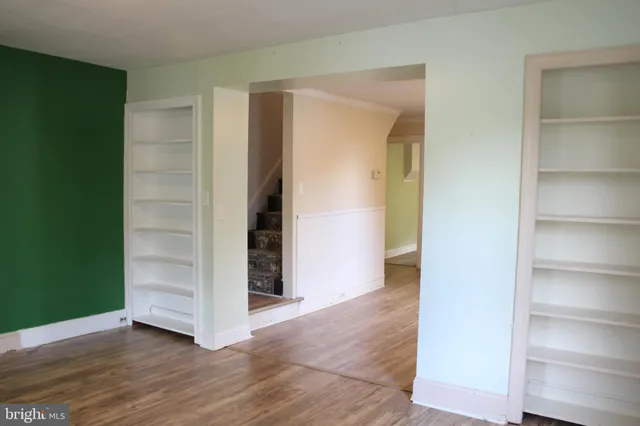 an empty room with wooden floor and closet