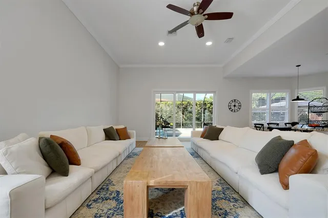 a kitchen with stainless steel appliances granite countertop a stove top oven a sink a refrigerator and white cabinets with wooden floor