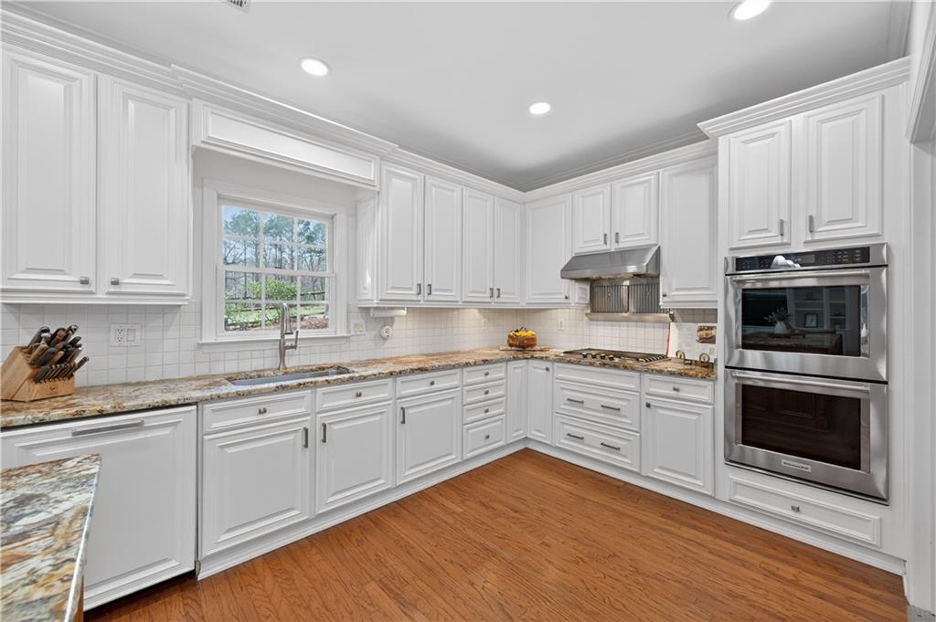 6460 Rutherford Place Suwanee, GA 30024 - Photo 11 of 35 a kitchen with cabinets stainless steel appliances and a window