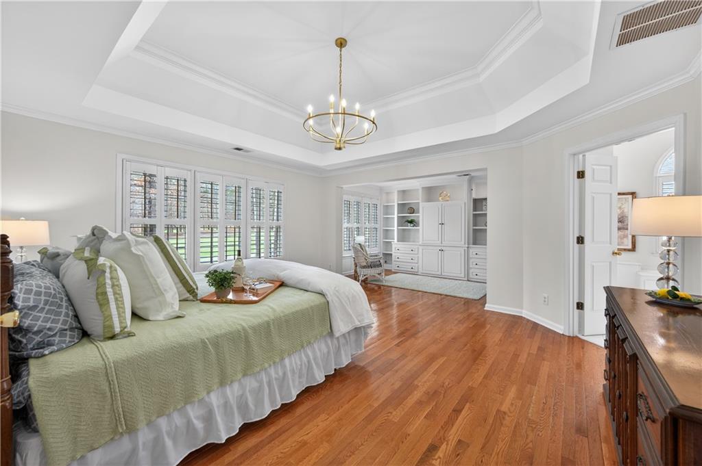 6460 Rutherford Place Suwanee, GA 30024 - Photo 4 of 35 a bedroom with bed and wooden floor
