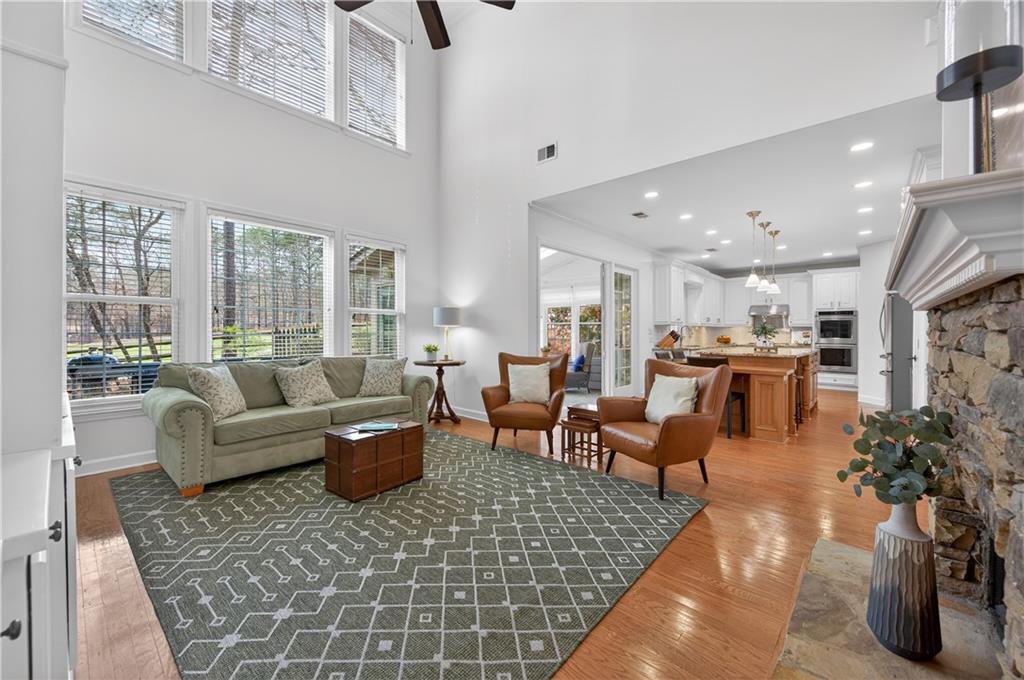 6460 Rutherford Place Suwanee, GA 30024 - Photo 8 of 35 a living room with furniture wooden floor and a large window