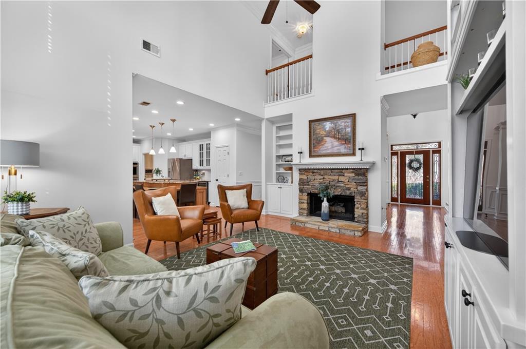 6460 Rutherford Place Suwanee, GA 30024 - Photo 9 of 35 a living room with furniture a fireplace and a flat screen tv