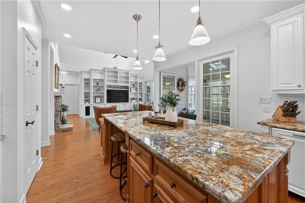 6460 Rutherford Place Suwanee, GA 30024 - Photo 10 of 35 a open kitchen with granite countertop a stove oven and a fireplace