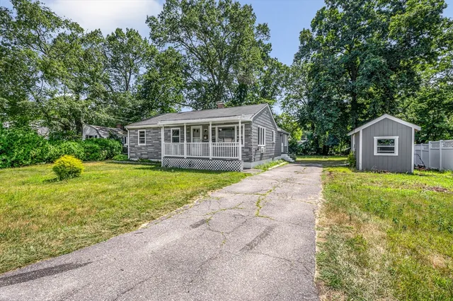 a front view of a house with a garden and yard