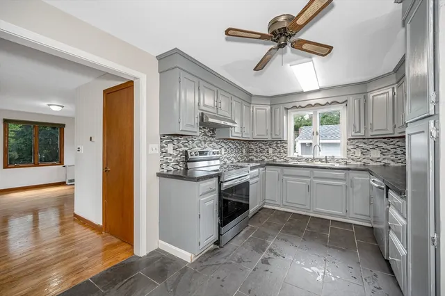 a kitchen with stainless steel appliances granite countertop a sink a stove cabinets and refrigerator