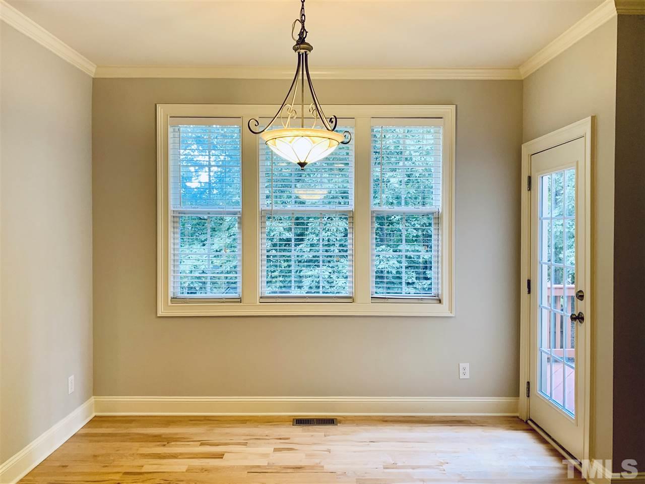 8917 Riverview Park Drive Raleigh, NC 27613 - Photo 12 of 29 a view of a room with window wooden floor and a chandelier