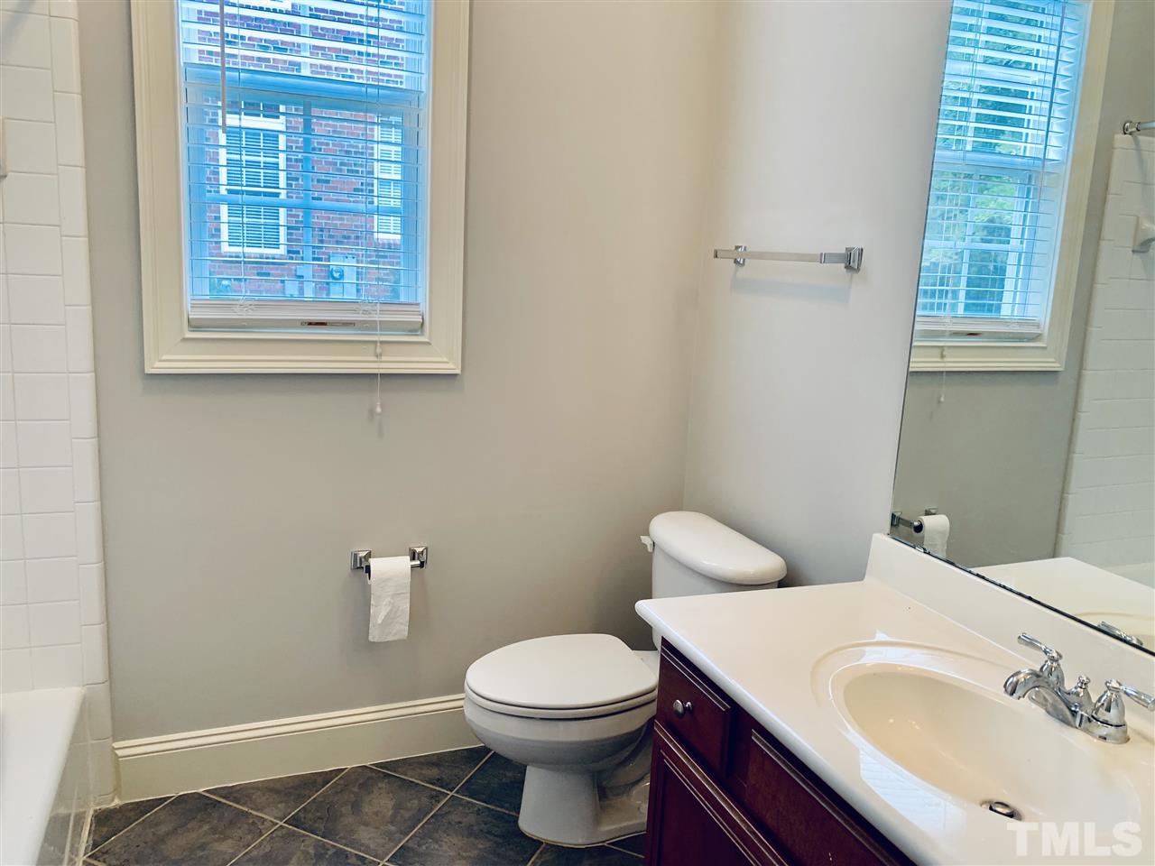 8917 Riverview Park Drive Raleigh, NC 27613 - Photo 14 of 29 a bathroom with a sink a toilet and a window