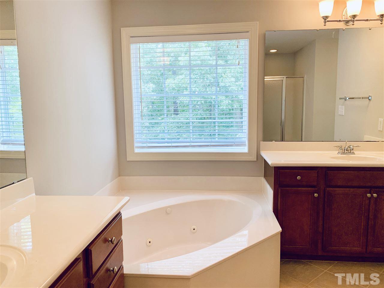 8917 Riverview Park Drive Raleigh, NC 27613 - Photo 18 of 29 a bathroom with a tub sink and mirror