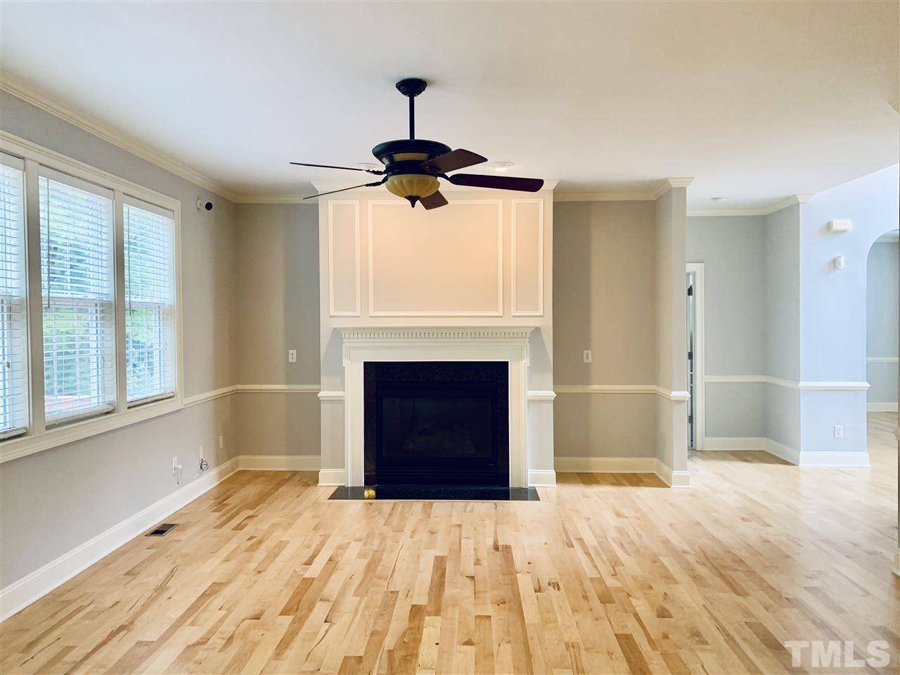 8917 Riverview Park Drive Raleigh, NC 27613 - Photo 8 of 29 a view of empty room with a fireplace and fan