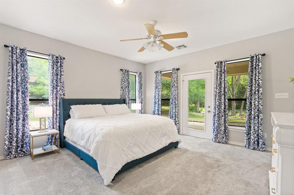 12041 Shady Creek Drive Whitney, TX 76692 - Photo 11 of 40 a bedroom with a large bed and a chandelier