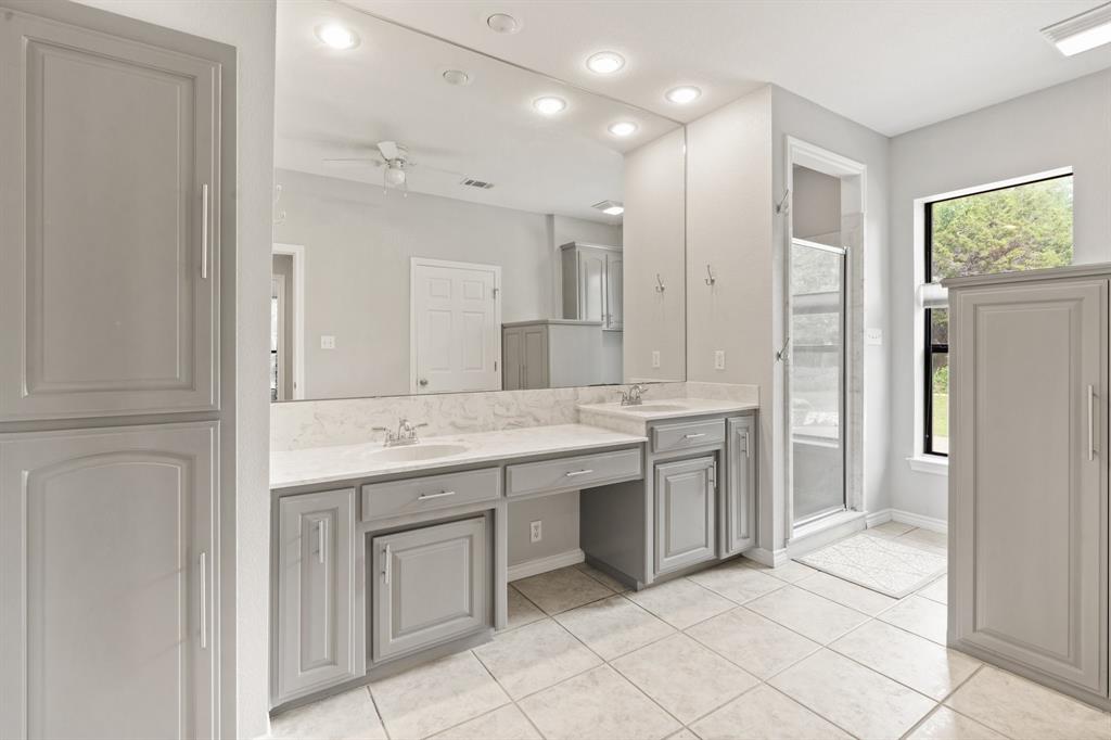 12041 Shady Creek Drive Whitney, TX 76692 - Photo 12 of 40 a bathroom with a granite countertop sink two mirror and a shower