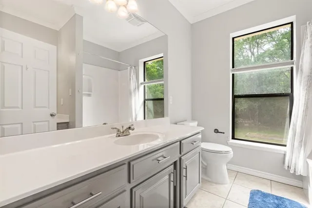 a bathroom with a sink a toilet and a window