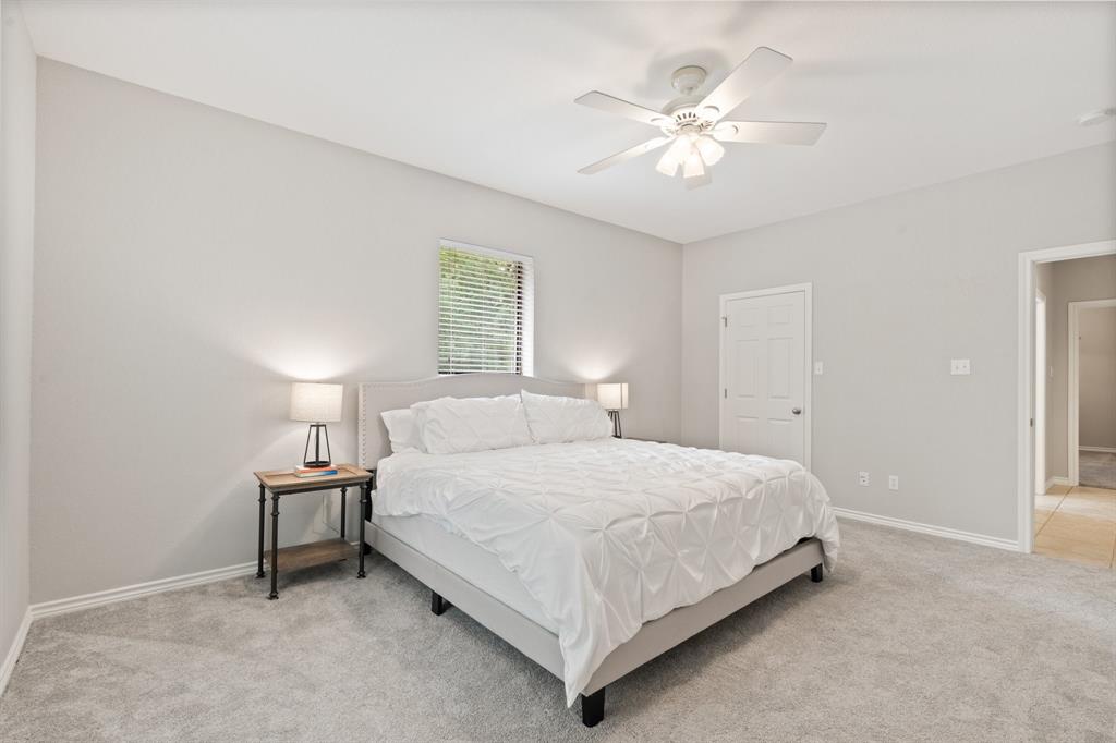 12041 Shady Creek Drive Whitney, TX 76692 - Photo 16 of 40 a bedroom with a bed and a chandelier