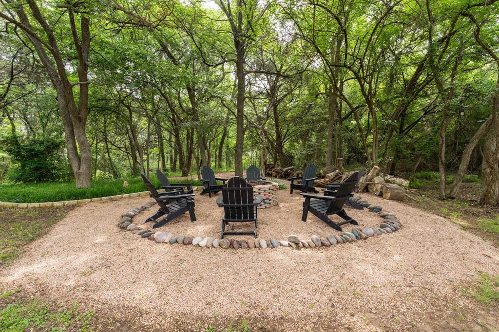 12041 Shady Creek Drive Whitney, TX 76692 - Photo 17 of 40 a view of backyard with table and chairs and a large tree