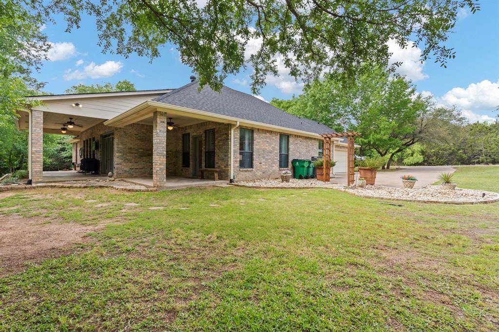 12041 Shady Creek Drive Whitney, TX 76692 - Photo 24 of 40 a front view of a house with garden