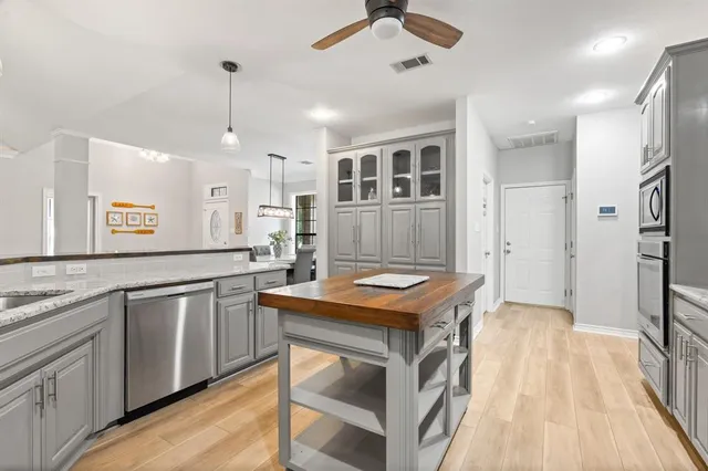 a kitchen with stainless steel appliances granite countertop a sink and a refrigerator