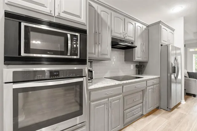a kitchen with stainless steel appliances granite countertop a stove microwave and refrigerator