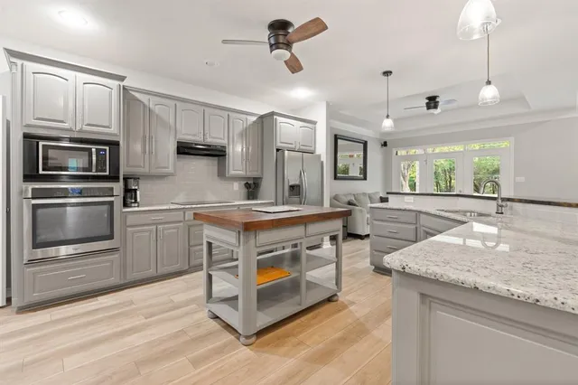 a kitchen with stainless steel appliances granite countertop a sink a stove and a refrigerator