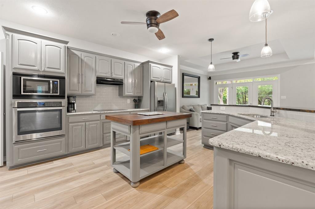 12041 Shady Creek Drive Whitney, TX 76692 - Photo 9 of 40 a kitchen with stainless steel appliances granite countertop a sink a stove and a refrigerator