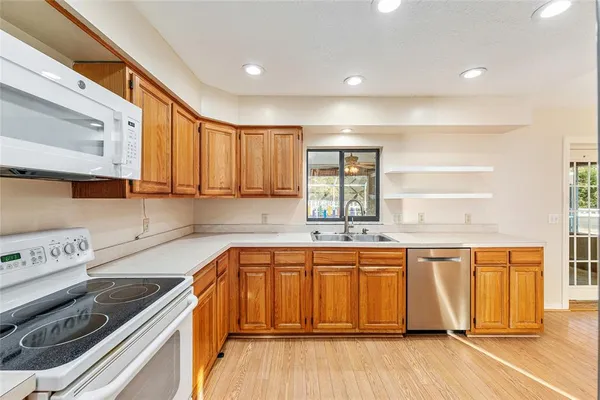 a spacious bathroom with stainless steel appliances granite countertop a sink and cabinets with wooden floor