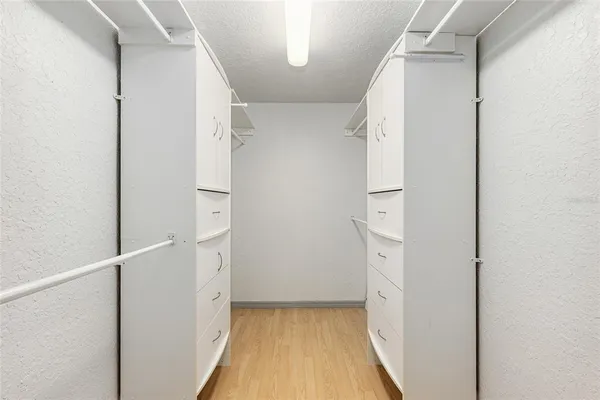 an empty room with wooden floor ceiling fan and windows