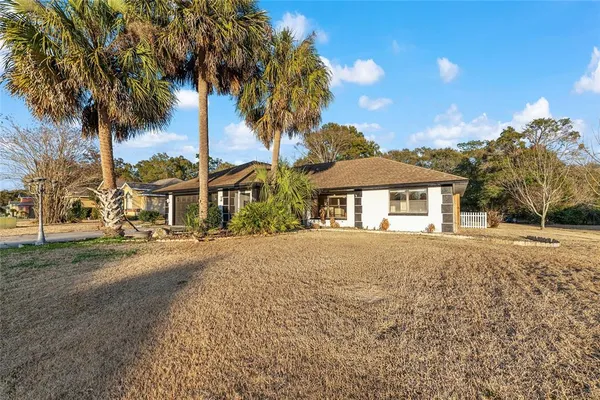 a front view of a house with a garden and yard