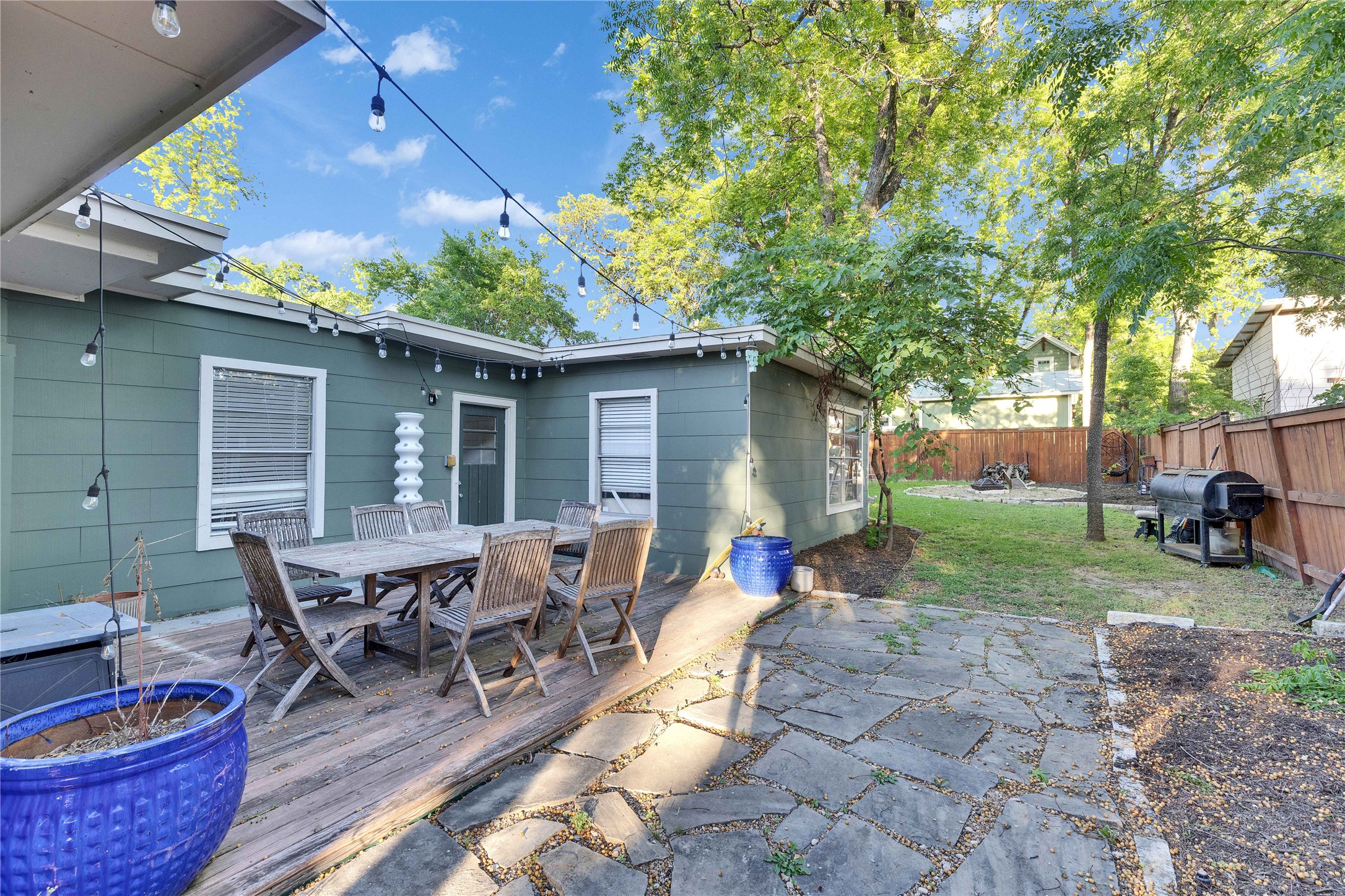 4607 Evans Avenue, Unit B Austin, TX 78751 - Photo 2 of 34 Exterior deck and flagstone patio area with string lighting and a fenced yard