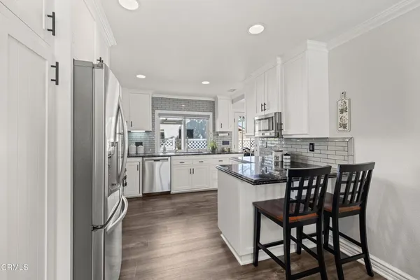 a kitchen with a table chairs refrigerator and cabinets