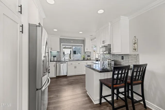 a kitchen with a table chairs refrigerator and cabinets